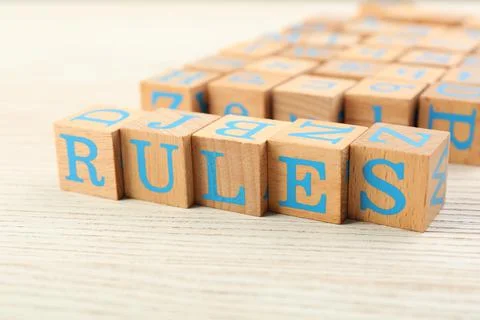 Word Rules made of cubes with letters on light wooden table Foto stock