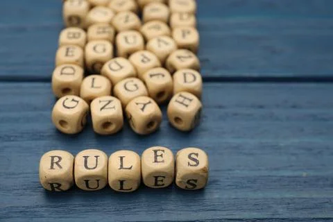 Word Rules made of cubes with letters on blue wooden table Stock Photos