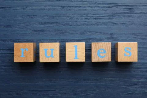 Word Rules made of cubes with letters on blue wooden table, top view Stockfoto's