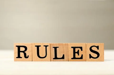 Word Rules made of cubes with letters on light wooden table Stockfoto's