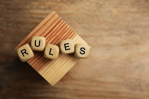Word Rules made of cubes with letters and block on wooden table, top view. .. Foto stock