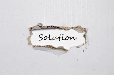 The word solution appearing behind torn paper Stock Photos