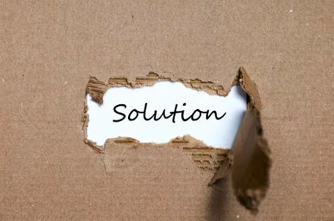 The word solution appearing behind torn paper Stock Photos