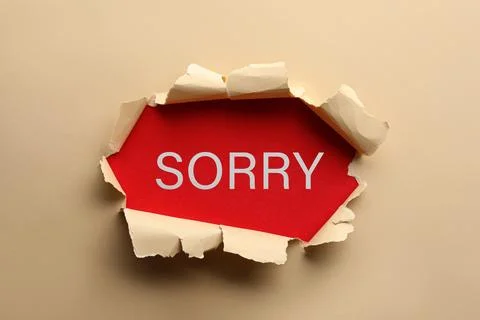 Word Sorry on red background, view through torn beige paper Stock Photos