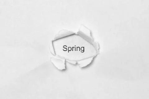 Word Spring on white isolated background through the wound hole in the paper. Stock Photos
