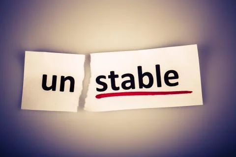 The word stable changed to unstable on torn paper and white background Stock Photos