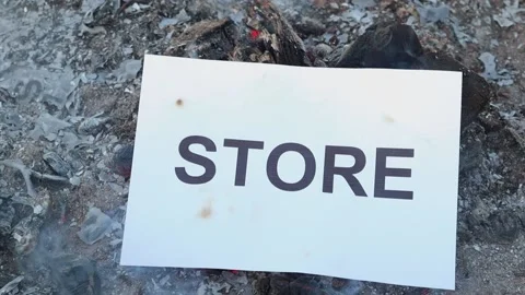 Word Store on a white sheet of paper burns into a fire against. Slow motion Vídeo Stock 142703258