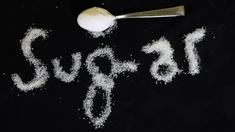 Word sugar created using white sugar crystals highlighting sweet food concept Stock Footage 337140652