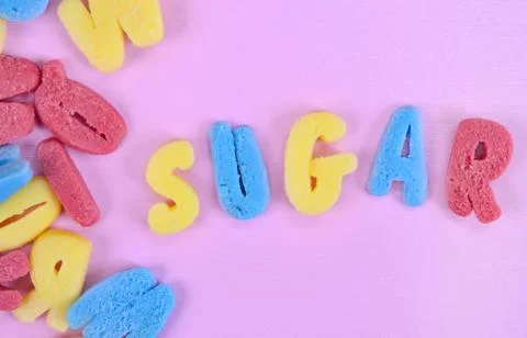 Word Sugar on pink table Stock Photos