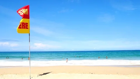 A word Swin Here on the red and yellow flags on the beach.To tell the point s Stock-Footage 79738123