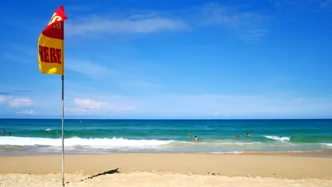 A word Swin Here on the red and yellow flags on the beach.To tell the point s Vidéo 79738196