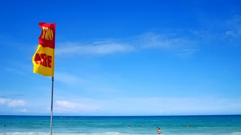 A word Swin Here on the red and yellow flags on the beach.To tell the point s Stockbeeldmateriaal 79738239
