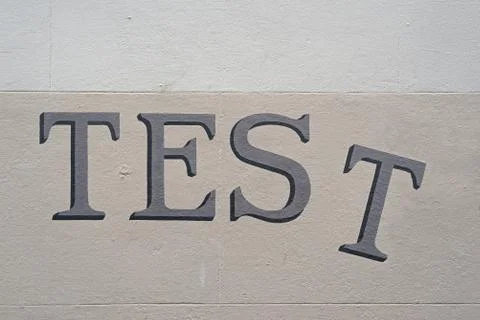 The word "TEST" painted in a serif handwriting type on a wall Stock Photos
