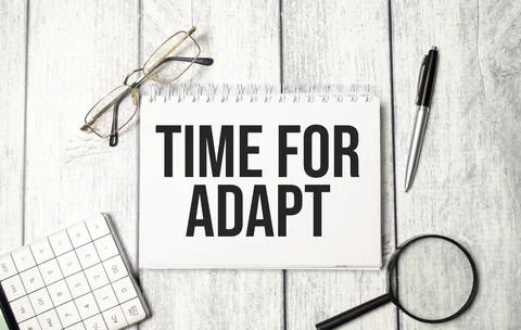 Word text TIME TO ADAPT on white paper notebook, business concept Stock Photos