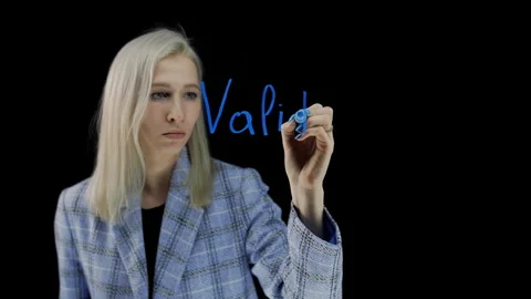 The word validators on a black background. A girl writes a word with a blue Stock Footage 241240360