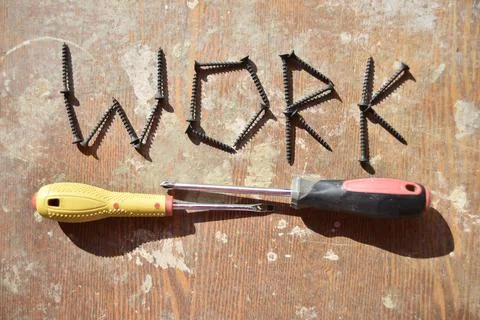 Word work made of screws and two screwdravers below Stock Photos