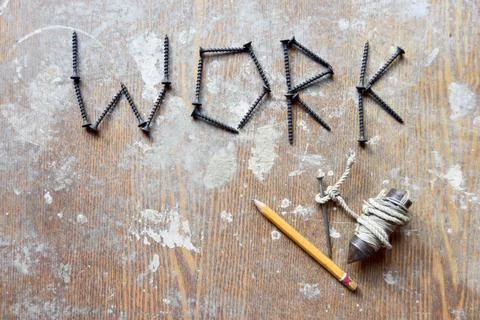 Word work made of screws and yellow pencil with handmade leveling device Stock Photos