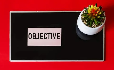 The word is written OBJECTIVE on a sticker and a black background. Stock Photos