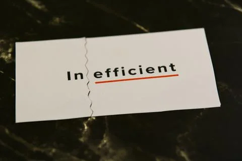 Wordplay on inefficiency with split text on a dark surface 스톡 사진