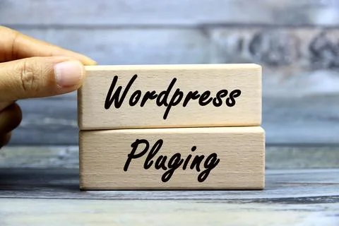 Wordpress playing wording  or text on wood block with hand.Grey wooden back.. Stock Photos