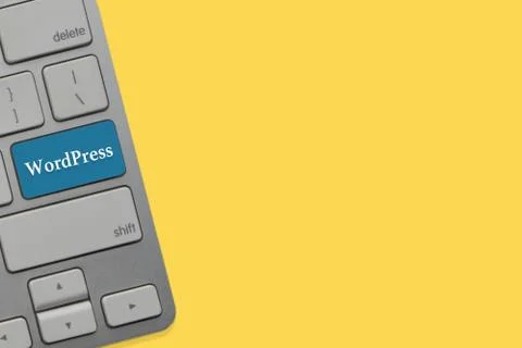 WORDPRESS text on keyboard over yellow background. Business and technology co 写真素材