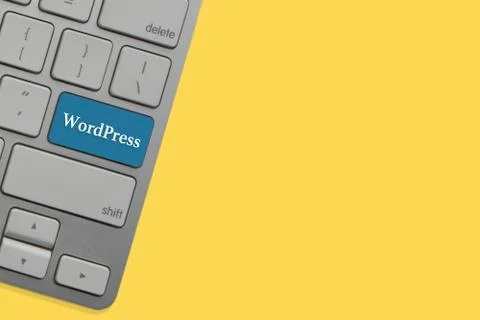 WORDPRESS text on keyboard over yellow background. Business and technology co Stock Photos