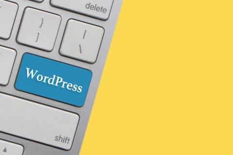 WORDPRESS text on keyboard over yellow background. Business and technology co 写真素材