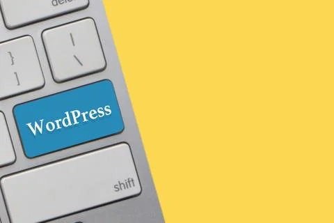 WORDPRESS text on keyboard over yellow background. Business and technology co Stock Photos
