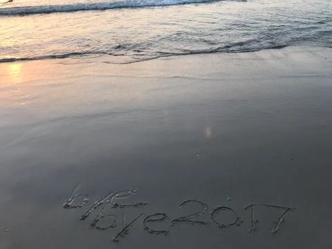 Words “bye bye 2017” when sunrise on the beach Stock Photos