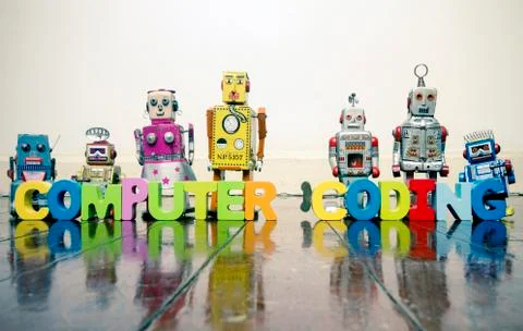 The words COMPUTER CODING with wooden letters and retro toy robots  on an old Stock Photos