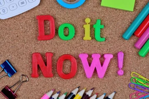 The words Do it now on cork Stock Photos