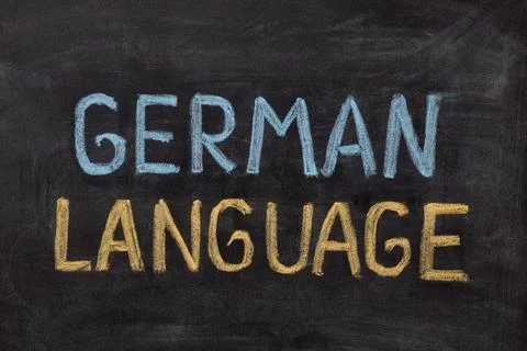 The words German Language handwritten with chalk on a blackboard. Stock Photos