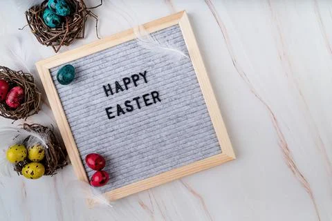 The words Happy Easter on grey felt letter board decorated with quail and chi Foto stock