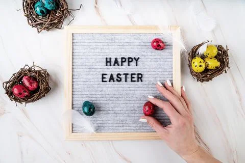 The words Happy Easter on grey felt letter board decorated with quail and chi Foto stock
