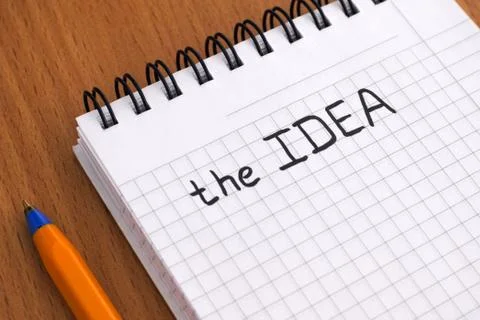 Words The Idea written on white note pad with ballpoint pen. Stock Photos