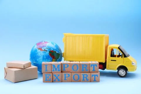 Words Import and Export made of wooden cubes, globe, boxes and toy truck on.. Foto stock