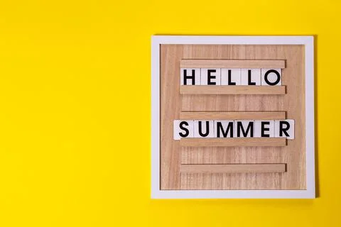 Words on the interior board HELLO, SUMMER on an isolated yellow textured back Stock Photos