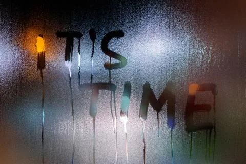 The words it's time written on night wet window glass close-up with blurred Photos