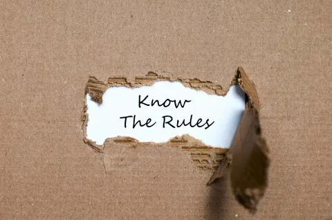 The words know the rules appearing behind torn paper Stock Photos