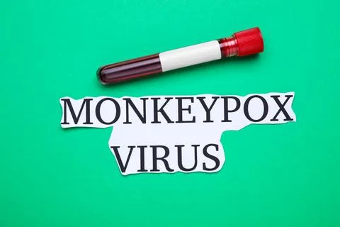 Words Monkeypox Virus and test tube with blood sample on green background, .. Foto stock