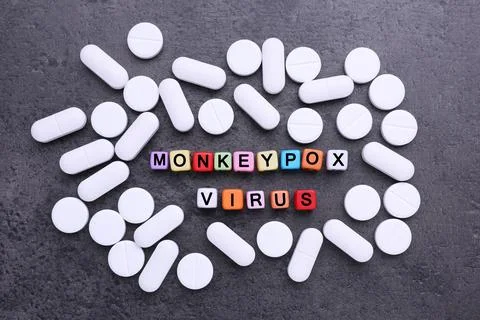 Words Monkeypox Virus made of cubes and pills on grey table, flat lay Foto stock