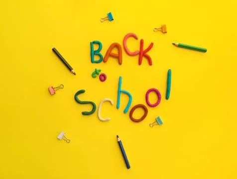 Words of multi-colored plasticine back to school and pens, paper clips, on Stock Photos