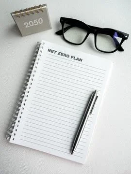 Words "Net Zero Plan" on blank vertical notepad page with pen, empty space .. 스톡 사진