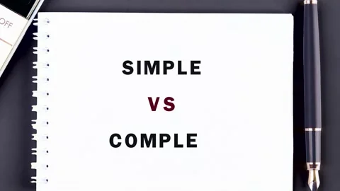 Words SIMPLE VS COMPLEX gradually appear on a pristine spiral notebook resting Stock Footage 331291518