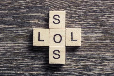 Words SOS and LOL on table made of wooden cubes elements Stock Photos