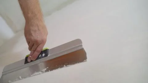 Work aligns with a spatula. Worker plastering a wall with a spatula. Stock Photos
