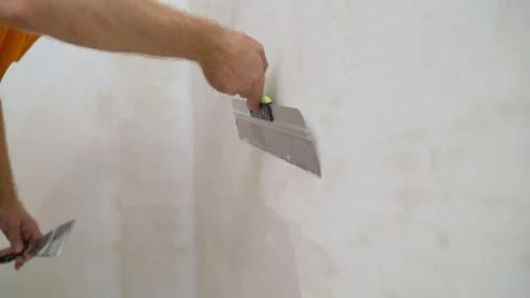 Work aligns with a spatula. Worker plastering a wall with a spatula. Stock Photos