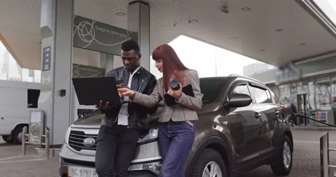 Work and break at petrol station. Shot of young African man and pretty Caucasian Stock Footage 152556140