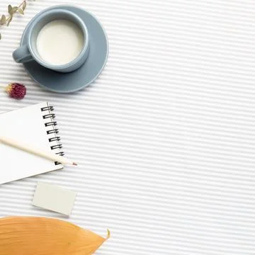 Work and study place. Notebook, cup of milk, pencil with dry plant Stock Photos