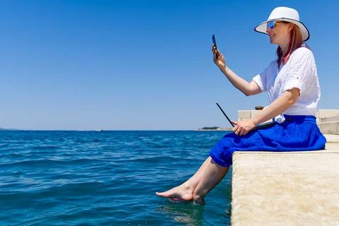 Work from anywhere. Side view of young woman, female freelancer in straw hat Stock Photos